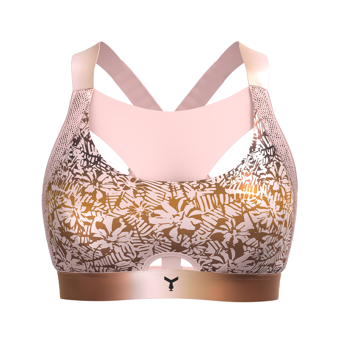 Front view of the soft pink Tigers Eye Orchid sports bra, featuring moulded cups for comfort and high support. The Vault Y-shaped front panel reduces vertical breast movement, with antibacterial-treated fabric. The front section showcases a soft baby pink floral pattern set against an ombre background, transitioning from brownish pink to orange-brown, inspired by the hues of the Tigers Eye crystal stone.